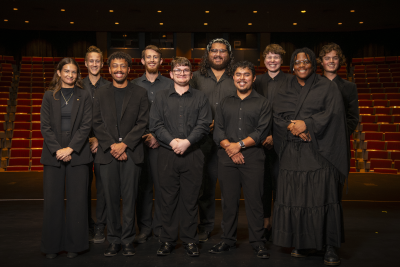 Group of percussion students standing, posing in concert black